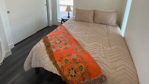 A bedroom with a bed, a window with blinds, a door, and a wall-mounted artwork of a pig. - "The Office" - located the beautiful wine & horse country of Santa Barbara (Santa Ynez)