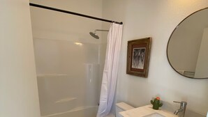 A bathroom with a shower, toilet, sink, and a mirror. - "The Office" - located the beautiful wine & horse country of Santa Barbara (Santa Ynez)