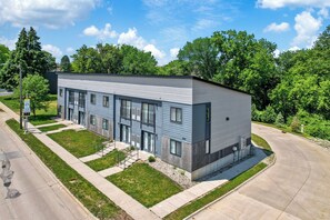 Un bâtiment moderne à deux étages, doté d’un toit plat, de grandes fenêtres et d’un numéro de maison bien visible.