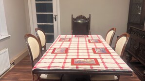 A dining room with a table set for four, a chandelier, and a cabinet. - Stylish 4-Bed Detached Home Close to Grantham Town & Amenities (Grantham)