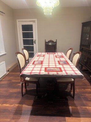 Ein Esszimmer mit einem Tisch für vier Personen, einer Chandelier und einem Schrank.