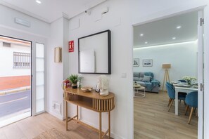 A modern interior with a wooden console table, a mirror, and a fire extinguisher.