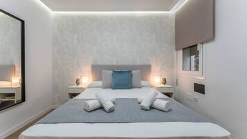 Een moderne hotelkamer met een groot bed, twee nachtkastjes, een spiegel en een raam.