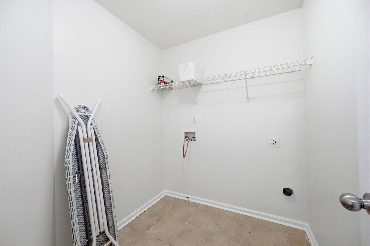 A small, white-walled room with a door, a radiator, and a shelf with a box on it.
