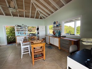 A kitchen with a wooden ceiling, a window, and a view of greenery outside. - Home on Beach on Private Island Available for Holidays Overlooking Caribbean Sea (St John)
