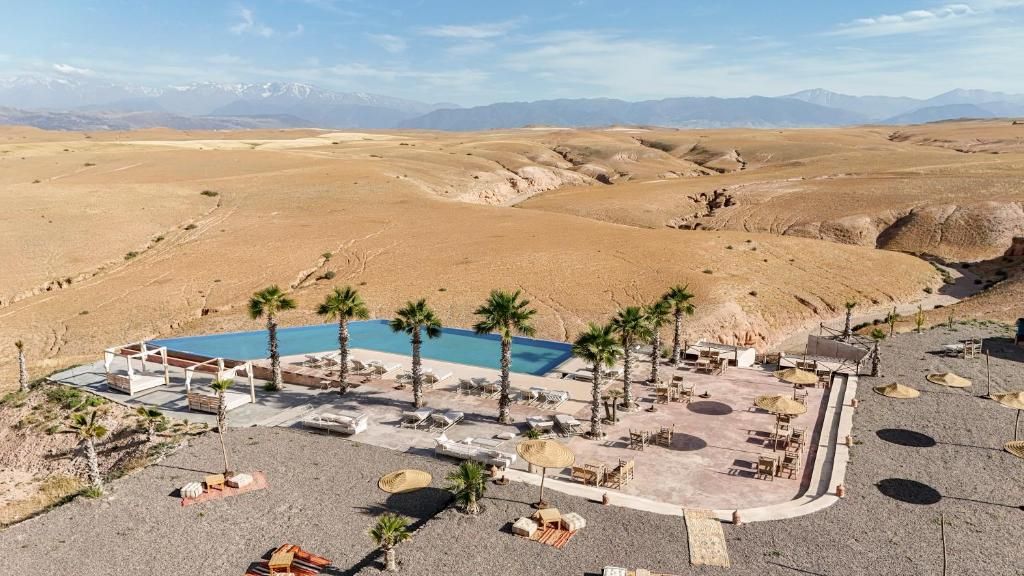 A resort with a pool area, lounge chairs, and palm trees.