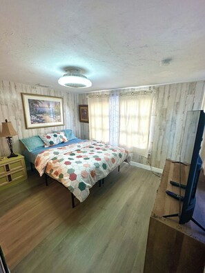 A bedroom with a bed, a television, and a painting on the wall. - Lovely 3-bedroom house with AC in North Fort Myers pet friendly (North Fort Myers)