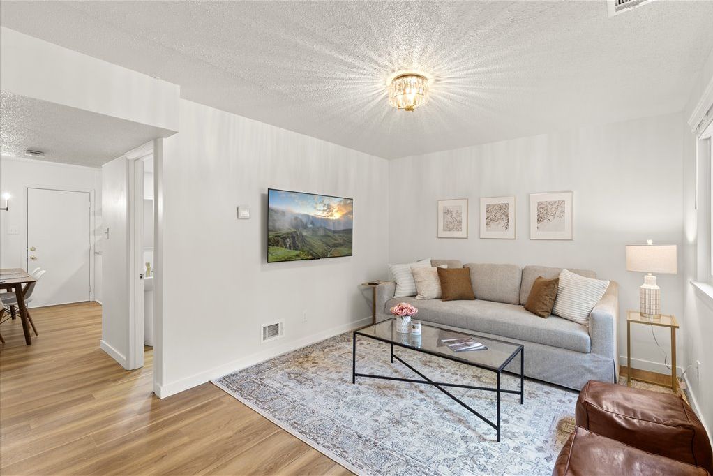 Ein Wohnzimmer mit einer Couch, einem Couchtisch und Kunstwerken an der Wand.