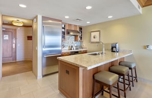 A modern kitchen with a central island, stainless steel appliances, and bar stools. - Oceanfront -Hyatt Vacation Club - 2BR Upper Floor - Ka'anapali Beach - Sleeps 7 (Lahaina)