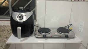 Een keuken met een koffiezetapparaat en een fornuis op een wit aanrecht.