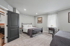 A bedroom with a bed, bedside table, and a window with curtains.