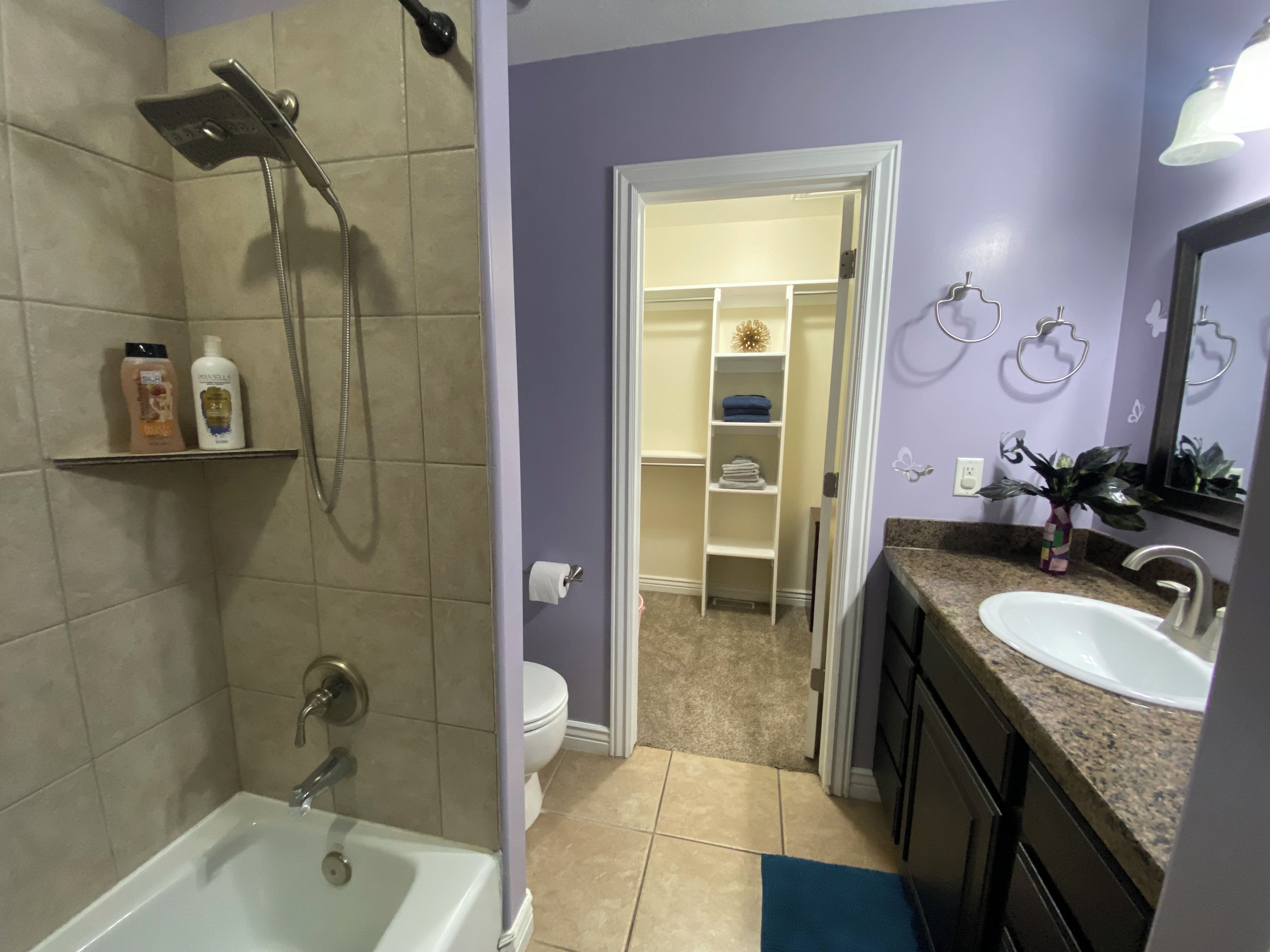 A bathroom with a bathtub, shower, toilet, and a vanity with a sink.