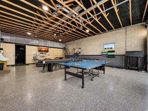 Ein Tischtennis-Tisch in einem Raum mit hoher Decke und freiliegenden Balken.