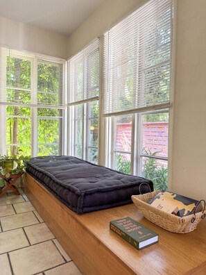 A room with a window seat, a book, and a basket. - Canyon Hill Retreat: Washer, Dryer, Full Kitchen, Patio, Private (Los Angeles)
