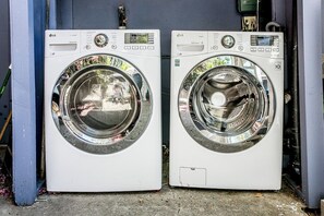 Deux lave-linge à chargement frontal blancs de la marque LG, placés côte à côte.