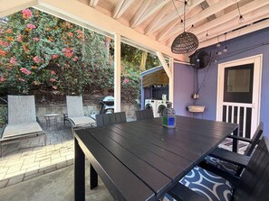An outdoor patio with a table and chairs, a washing machine, and a fan. - Canyon Hill Retreat: Washer, Dryer, Full Kitchen, Patio, Private (Los Angeles)