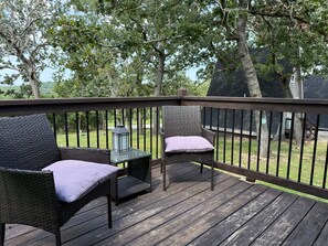 A wooden deck with wicker furniture and a lantern. - Table Rock Lake A-Frame Cabin | Black Oak Lodge 3 (Lampe)
