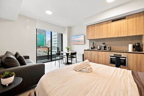 A modern hotel room with a bed, a sofa, a dining table, and a kitchenette. - Modern Miami Studio | 801B | Pool Hot Tub & Gym (Miami)