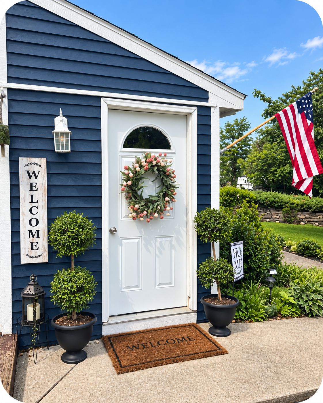 Uma casa com porta branca, placa de boas-vindas, grinalda e bandeira americana.