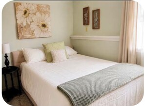 A bedroom with a bed, pillows, a bedside table, and wall art. - Cozy & Quiet Country 1-Bedroom Stay with Private Living Room, Bath and Entrance (Elbridge)