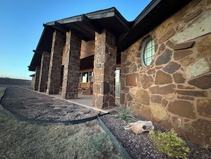 A stone building with a covered porch and a circular window.