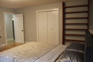 Ein Schlafzimmer mit einem Bett, einem Kleiderschrank und einer eingebauten Regaleinheit.