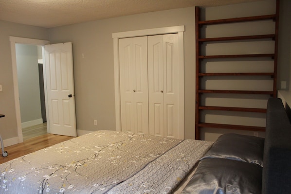 Une chambre à coucher comprenant un lit, une armoire et une étagère intégrée.