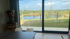 Ein Essbereich mit Blick auf einen Teich und Felder.