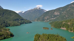 A mountainous landscape with a lake surrounded by dense forests and a prominent mountain peak. - Your Cascade river retreat awaits (Marblemount)