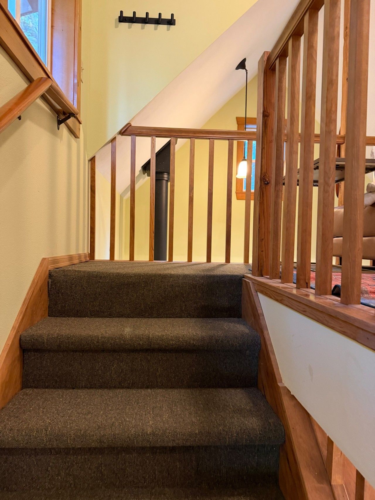 A staircase with wooden railings and carpeted steps leading to an upper floor.