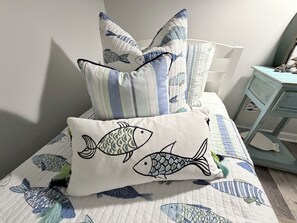 A bed with a quilted bedspread featuring fish designs, a pillow with fish embroidery, and striped pillows. - Cozy & Convenient 2-bedroom Cottage in Foley (Foley)