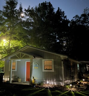 A small, single-story wooden cabin with a porch, a door, and a window with shutters. - Cozy & Convenient 2-bedroom Cottage in Foley (Foley)