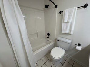 Ein Badezimmer mit Badewanne, Toilette und Handtuchhalter.