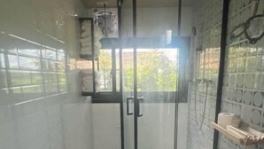 Un bagno compatto con WC, lavabo e cabina doccia.