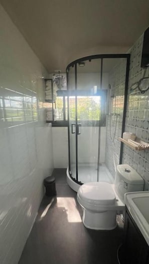 Ein kleines Badezimmer mit Toilette, Waschbecken und Duschkabine.