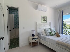 Ein Schlafzimmer mit einem Bett, Nachttisch und einer Klimaanlage.