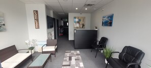 A hotel lobby with a reception desk, seating area, and artwork on the walls. - Modern Deluxe Loft 103 (Peachland)