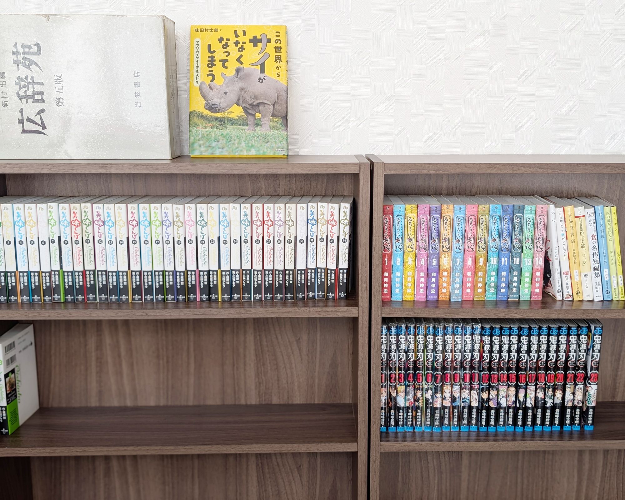 A bookshelf with multiple rows of books, some with colorful spines and others with plain covers.
