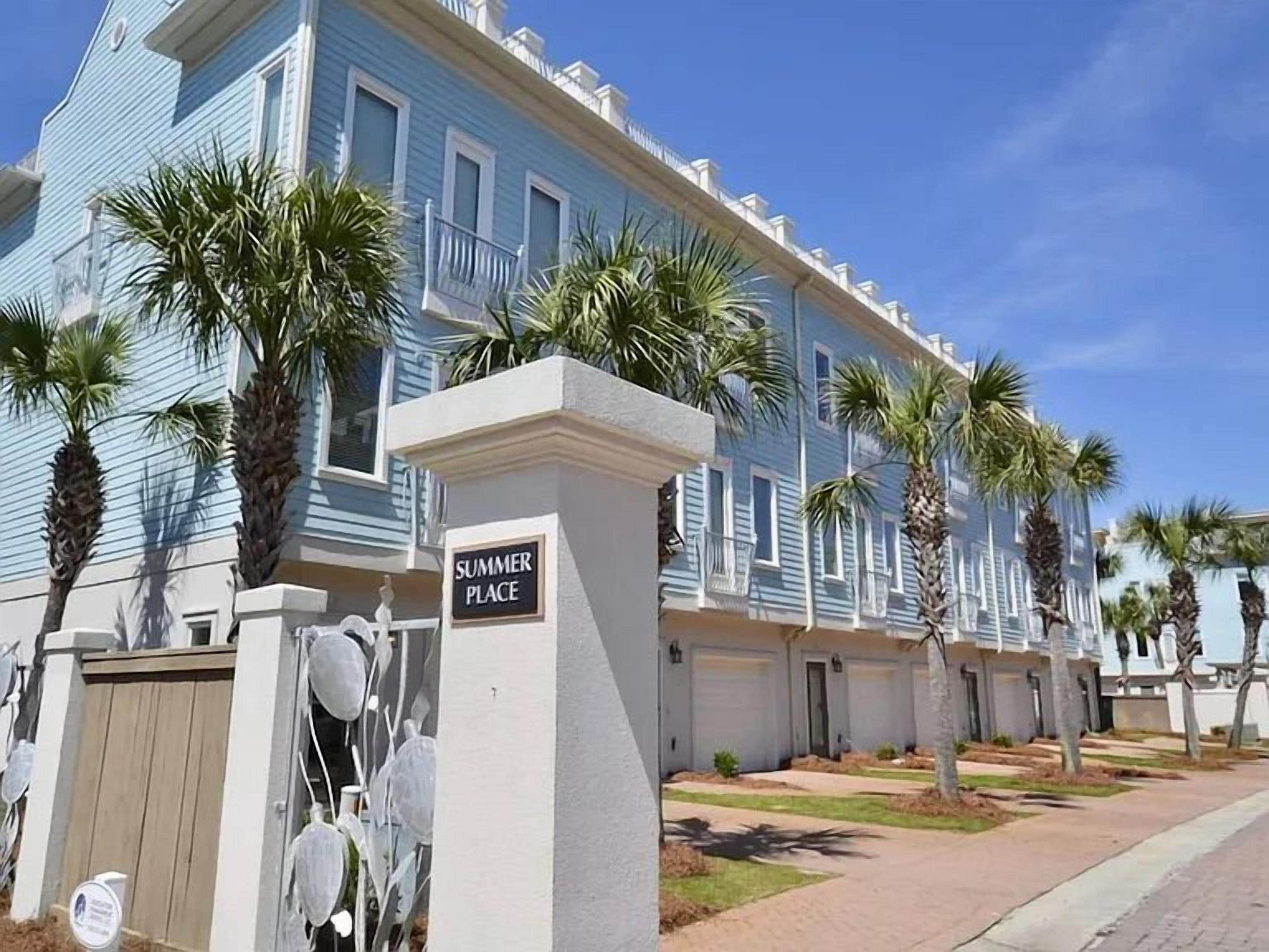 Uma fileira de edifícios azuis com uma placa que diz 'SUMMER PLACE'.