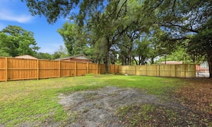 A backyard with a wooden fence, a shed, and a grassy area. - Modern 3BR Wilmington Cottage Pet-Friendly • Near Beach & Downtown (Wilmington)