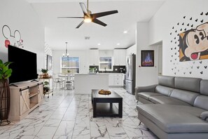 Una sala de estar moderna con un sofá, una mesa de centro y un televisor.