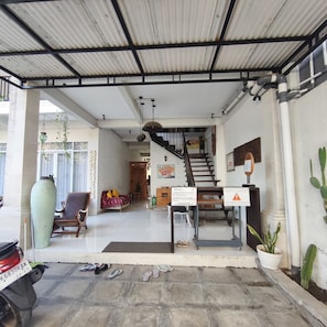 A covered entrance area with a staircase, a welcome sign, and a parking sign. - OYO 95416 Griya House Bstc (Bali)