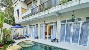 Um edifício moderno com piscina, área de estar ao ar livre e varanda coberta.