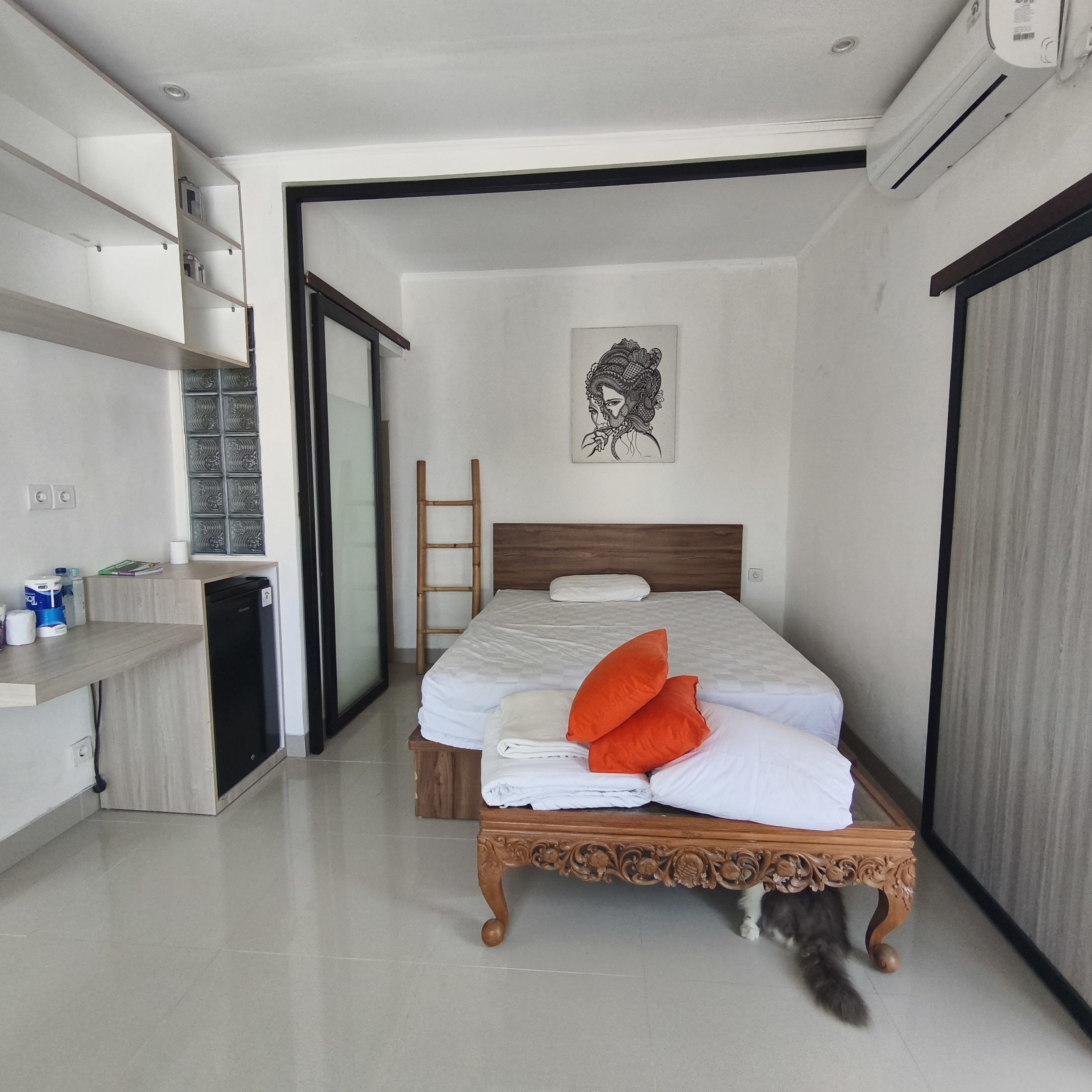 Quarto moderno com cama, mesa de cabeceira, armário e banheiro.