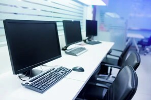 Ein moderner Büroarbeitsplatz mit mehreren Computerarbeitsstationen, jeweils ausgestattet mit Monitor, Tastatur und Maus.
