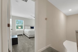A bedroom with a bed, a nightstand, a window, and a door. - Modern Orlando getaway near Disney & Universal! (Davenport)