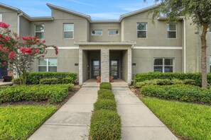A modern building with a symmetrical facade, numbered units, and a central entrance. - Modern Orlando getaway near Disney & Universal! (Davenport)