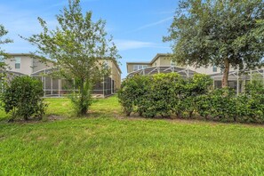 A residential area with houses, a grassy lawn, and trees. - Modern Orlando getaway near Disney & Universal! (Davenport)