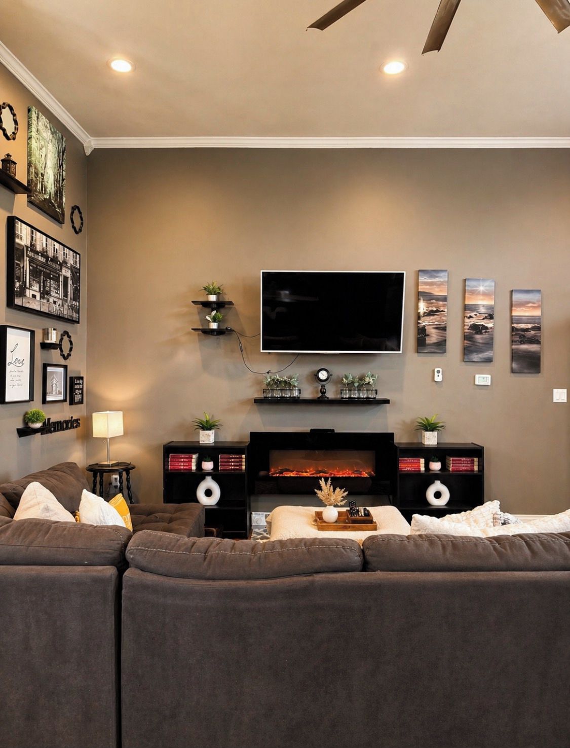 A living room with a large flat-screen TV, a fireplace, and a sofa.