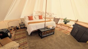 A tented accommodation with a bed, bedside table, and a small cabinet. - The Palisade Tent at Gateway Glamping (Gateway)